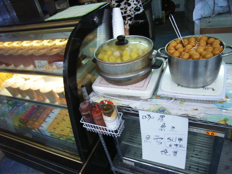 Curry fish balls and fish siu mai trays at a Hong Kong street stall with skewers